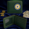 A dark green leather bifold wallet shown closed and open on a dark blue velvet background, surrounded by decorative coins and banknotes. The closed wallet features a circular rainbow emblem with a stylized monogram, and the open wallet reveals interior card slots and ID window.
