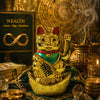 Gold cat figurine with green belly and black text, surrounded by coins and books on wealth.