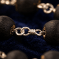 Close-up of a silver chain with black beads on a dark background