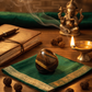 Decorative setup with a statue, books, and incense on a wooden surface.