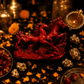 Red horse sculpture with gold coins and dried flowers on a dark background