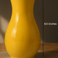 Yellow vase on a wooden surface with measurements indicated