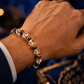 Hand wearing a beaded bracelet with a blurred decorative background