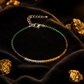 Bracelet with green, gold, and silver beads on a dark surface with gold rocks.