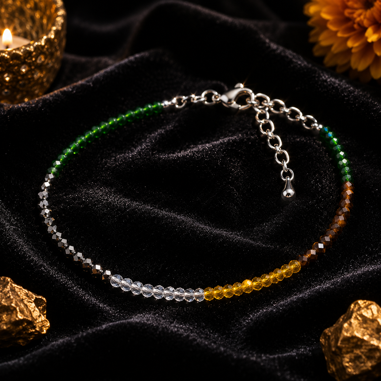 Multicolored beaded bracelet on a dark fabric background with gold rocks and a candle.