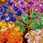 Colorful gemstone tree with blue, purple, green, yellow, orange, and red stones on a blurred background.