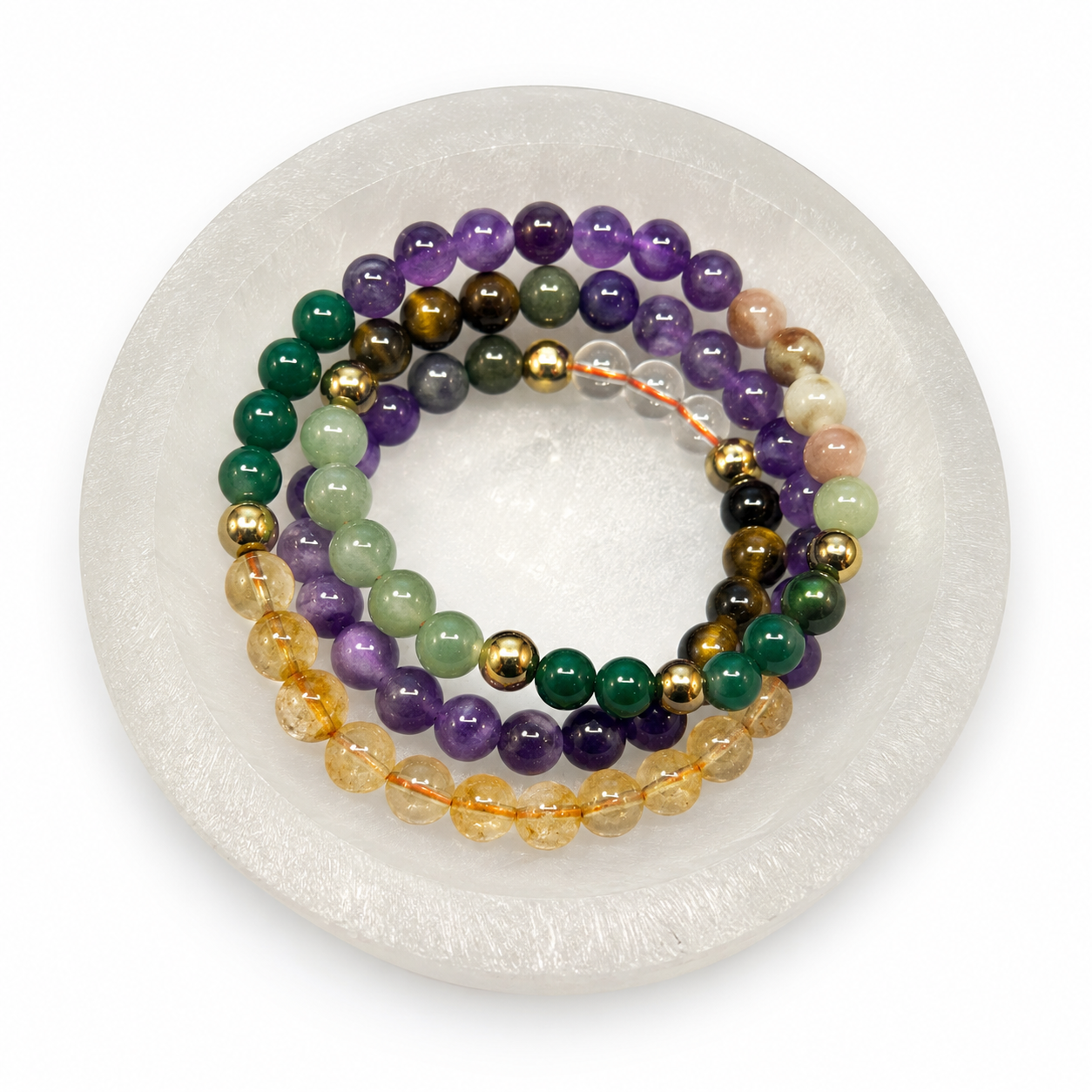 Set of colorful beaded bracelets on a white round stand