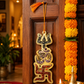 Decorative Swastika symbol hanging on a wooden door with marigold garlands.