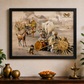 Framed artwork depicting traditional scene with people and animals on a wall above a wooden table.