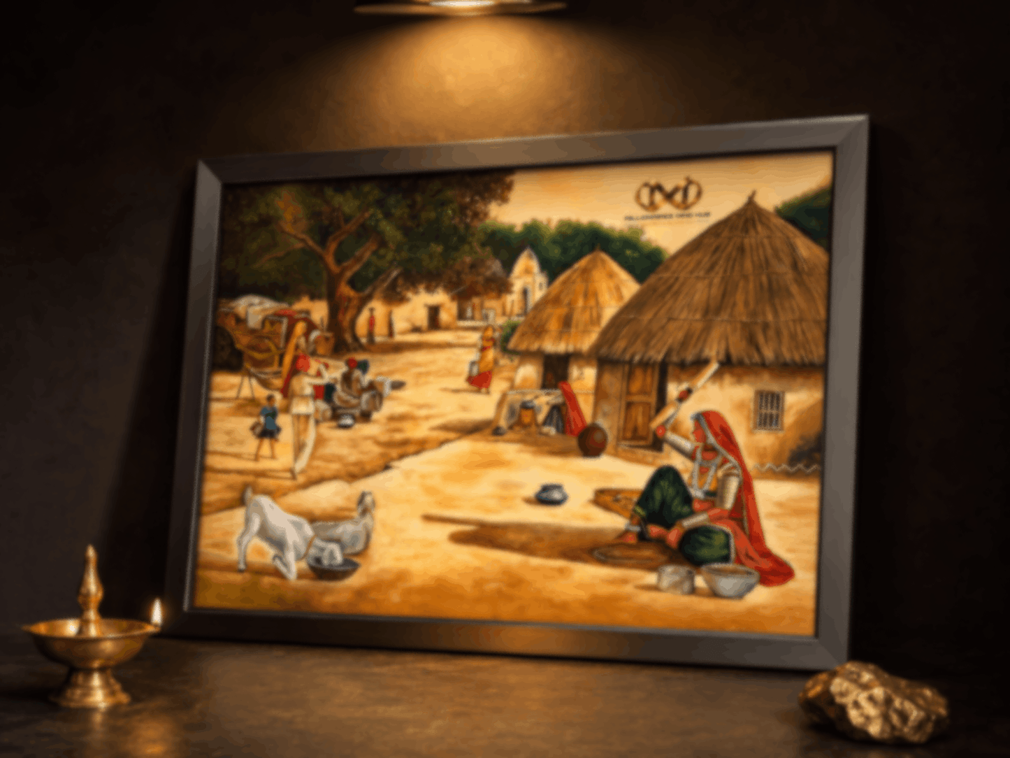 Framed artwork depicting a village scene with people and animals on a dark surface.