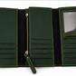 A dark green faux leather wallet shown in multiple views: closed with gold logo detailing, open to reveal interior card slots and a clear ID window, held open by a hand, and styled on a beige surface with accessories.