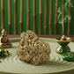 Decorative setting with a rock, incense burner, and Buddha statue on a green tray.